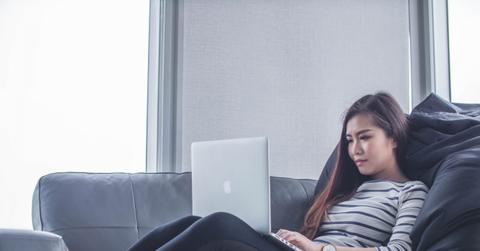 women sitting on couch with laptop