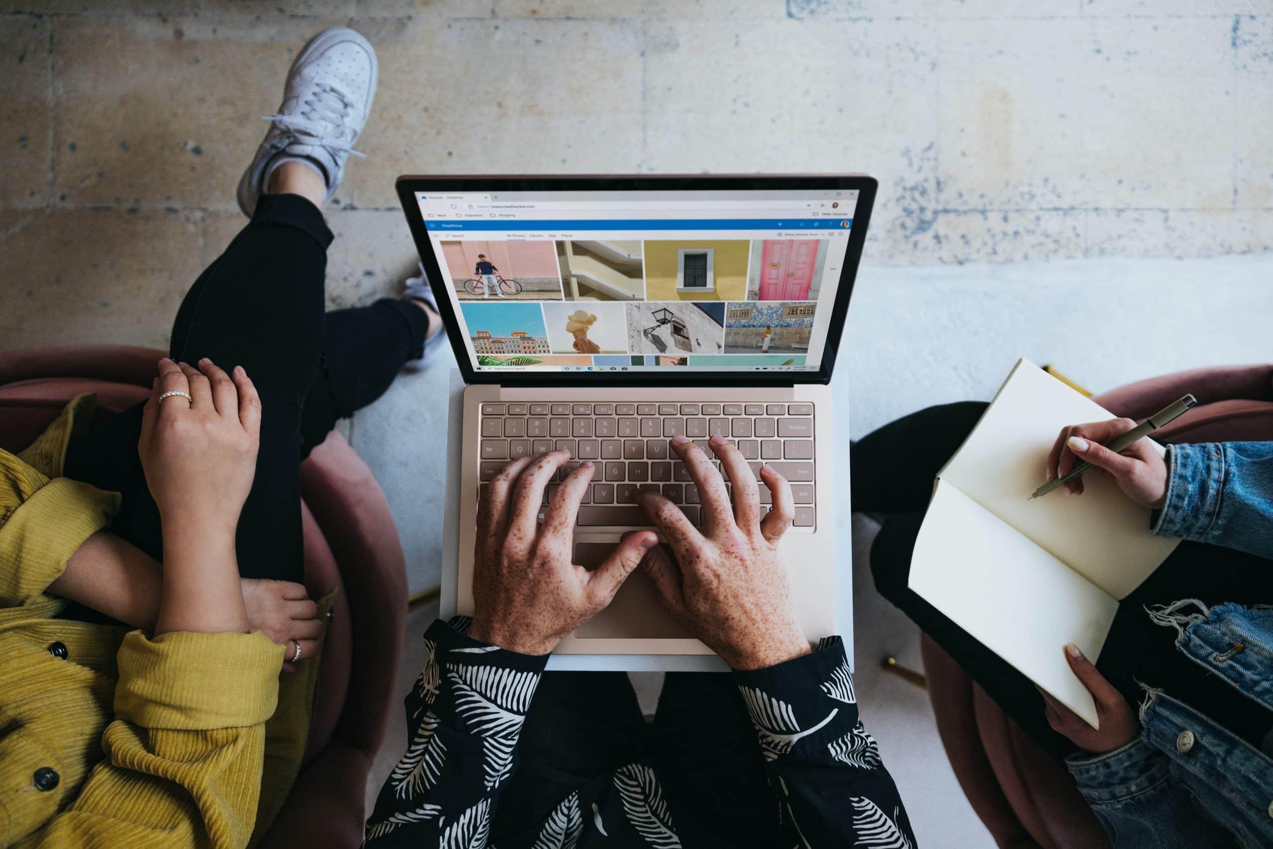 three people using a laptop