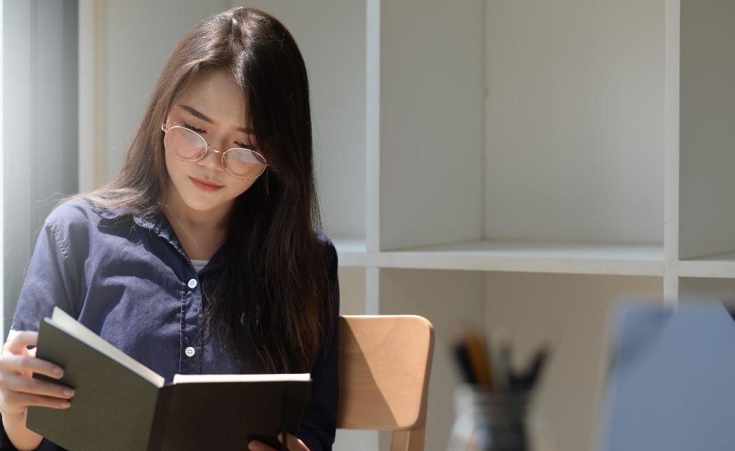 woman in glasses reading a book