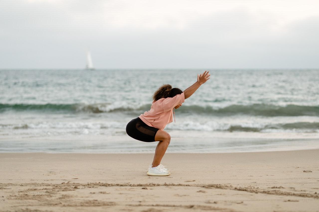 woman stretching on beach