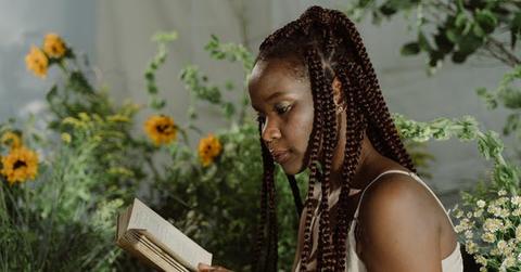 Woman reading by sunflowers