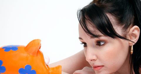 Woman staring at a colorful piggy bank