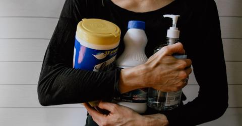 woman holding cleaning products
