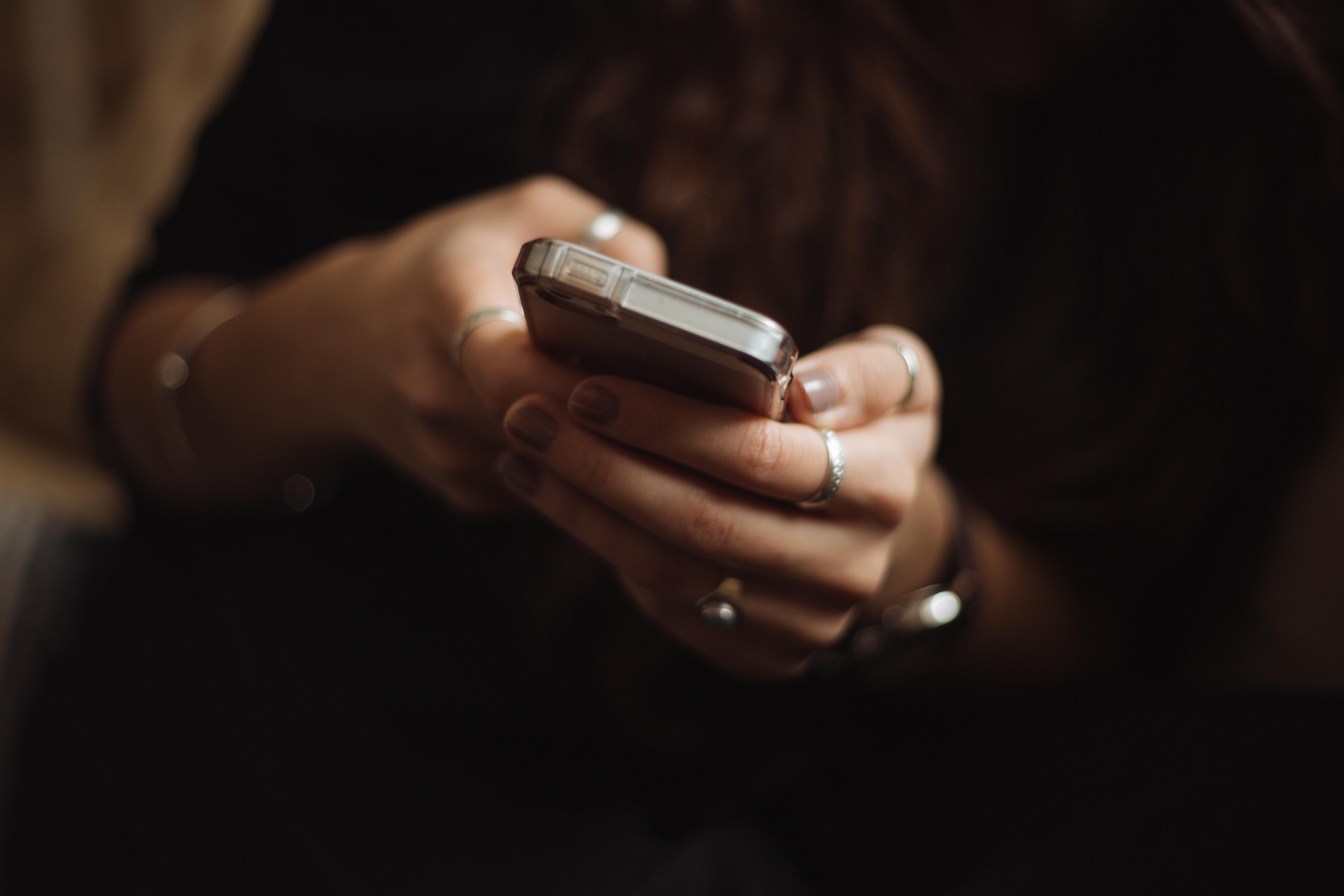 Close-up of hands holding a cell phone.