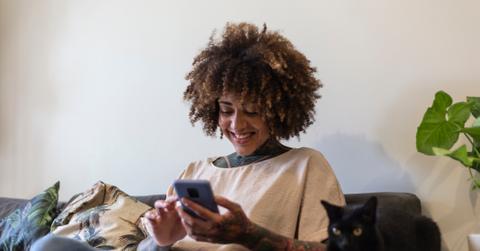 Black woman making purchases by cell phone with credit card