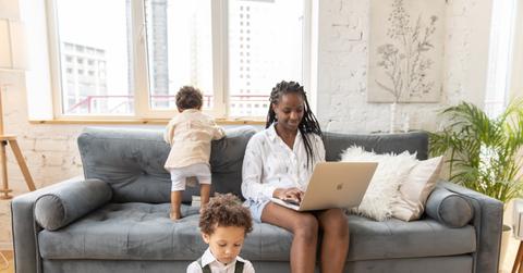 Black mom working at home with two kids