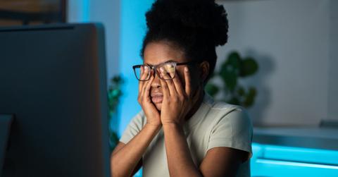 Overworked african woman freelancer feeling eye strain and fatigue during prolonged computer use