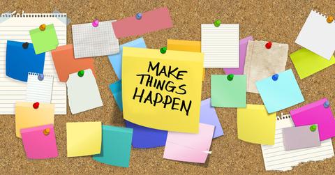 bulletin board covered in sticky notes, including one center reading: Make Things Happen
