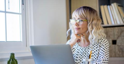 Thoughtful serene business woman looking away thinking solving problem at work, happy smiling young middle age woman relax lost in thought reflecting sit with laptop. Lifestyle of businesswoman