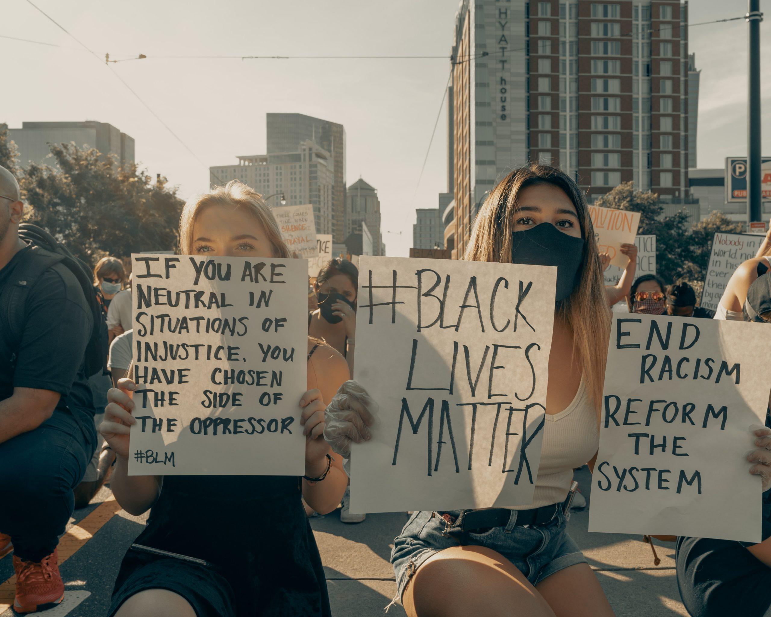 two women holding signs protesting