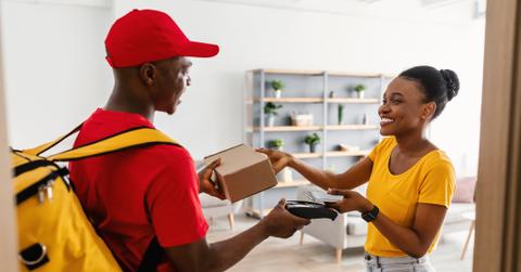 Black Lady Paying With Phone Receiving Package At Home