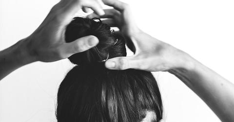 girl tying hair into bun