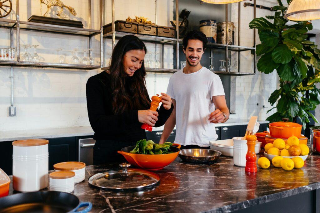 man and woman in kitchen cooking 