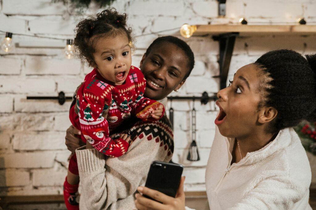 two women and baby looking at phone