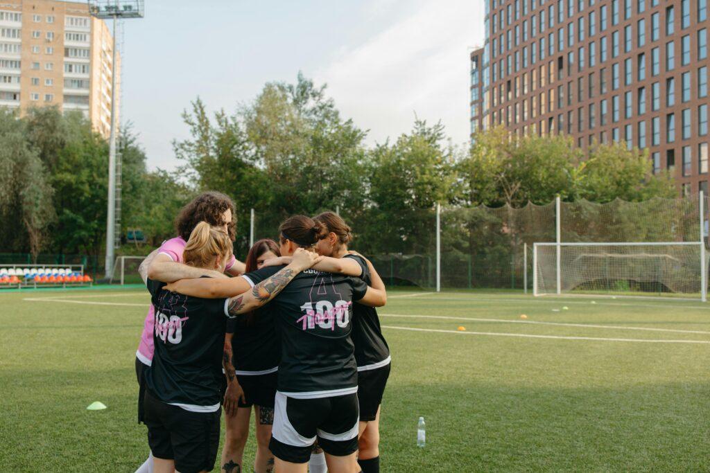 teammates huddling by field