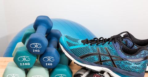 dunbbells, fitness shoes, and other fitness gear piled together, ready to workout