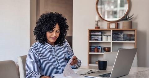 Smiling female entrepreneur going through paperwork at her dining table