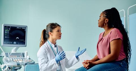 Female doctor talking to black woman during medical examination at the clinic.