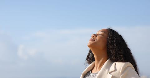 Black woman breathing in winter on the beach