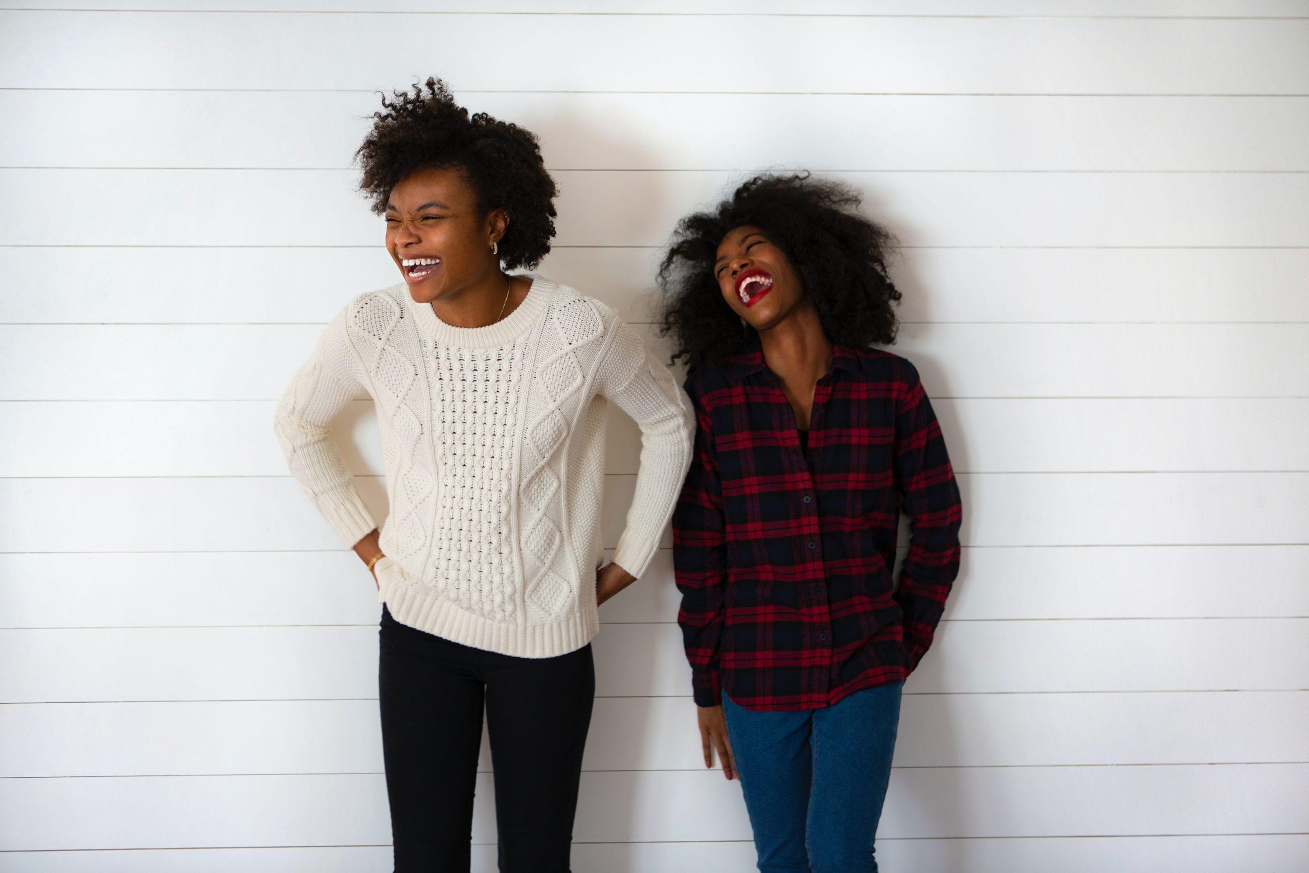 black women leaning on a wall 