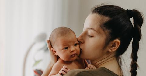 Loving mother carying of her newborn baby at home. Bright portra