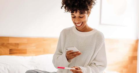 Woman taking a picture of her home pregnancy test