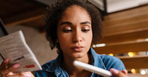 Young black woman holding pregnancy test and instruction at home