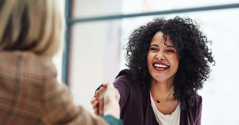 Handshake with a happy, confident and excited business woman or human resources manager and a female colleague, partner or employee. An agreement, deal or meeting with a coworker in the boardroom