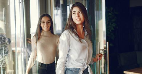 Two girls standing at the cafe and posing on the camera