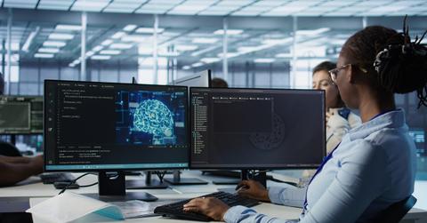 Woman leaving desk after finishing programming tasks in AI data center