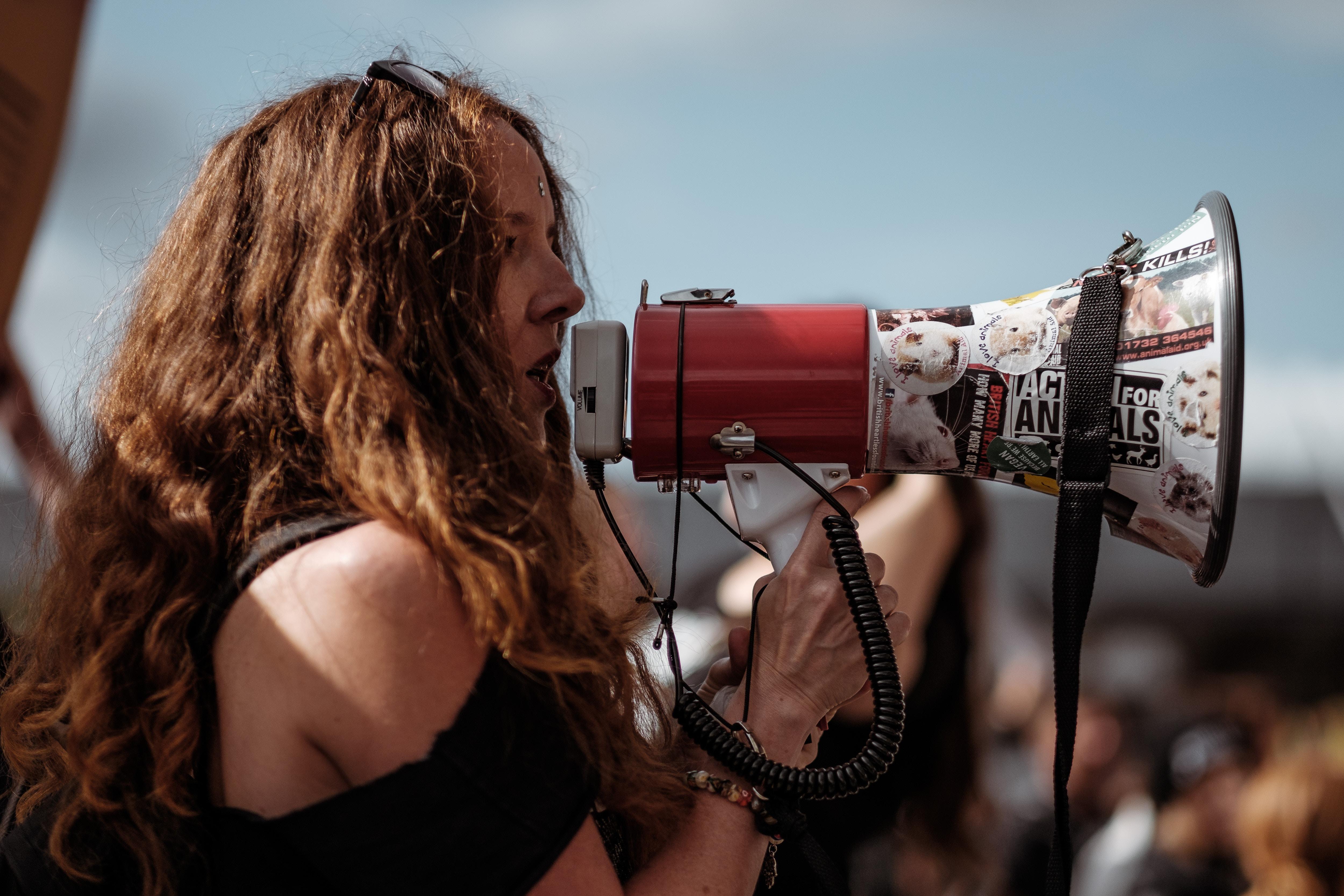 Woman speaking into a megaphone at a protest.