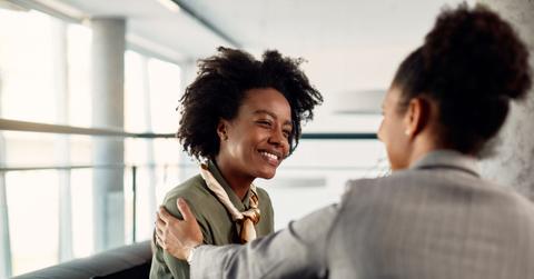 Happy African American business apprentice having meeting with her mentor in the office.