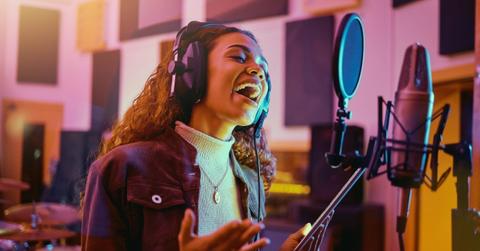 Tablet, music and woman singing in a studio for radio, song production and rehearsal. Creative, voice and a singer making a record, track or recording a musical sound as a professional artist