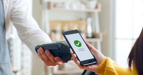Customer using smartphone for NFC payment at cafe restaurant, ca