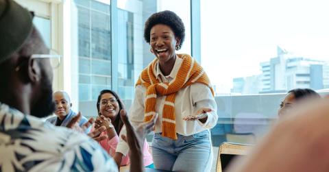 Diverse tech startup team in meeting with black woman leading discussion with enthusiasm