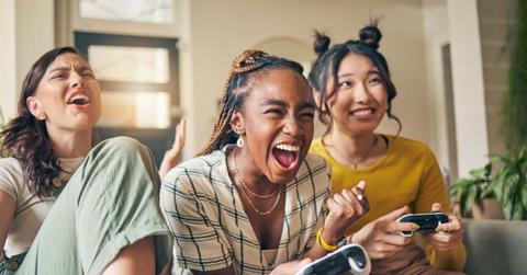 Friends, women and gaming on tv, winner in home living room on sofa and smile, relax and bonding. Television, girls and celebration on video game success on couch, esports competition and excited