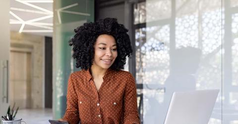 Successful happy accountant financier with a calculator prepares a financial report and fills in table forms, businesswoman works with papers, contracts inside office, female worker with a laptop