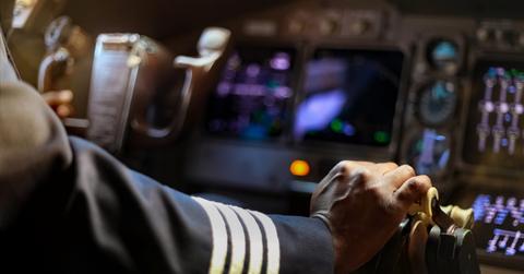Cropped Hands of African Pilot flying a commercial airplane, coc