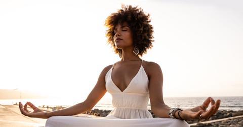 beautiful african woman in yoga position with sunset background.