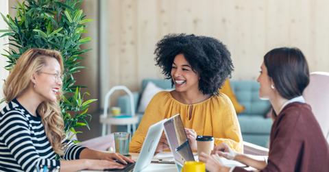 Casual multiethnic business women working with laptops while talking of they new projects together in coworking place.