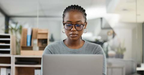 Laptop, office and business black woman typing online for research, internet and browse website. Corporate, professional and female worker busy on computer working on report, project and planning