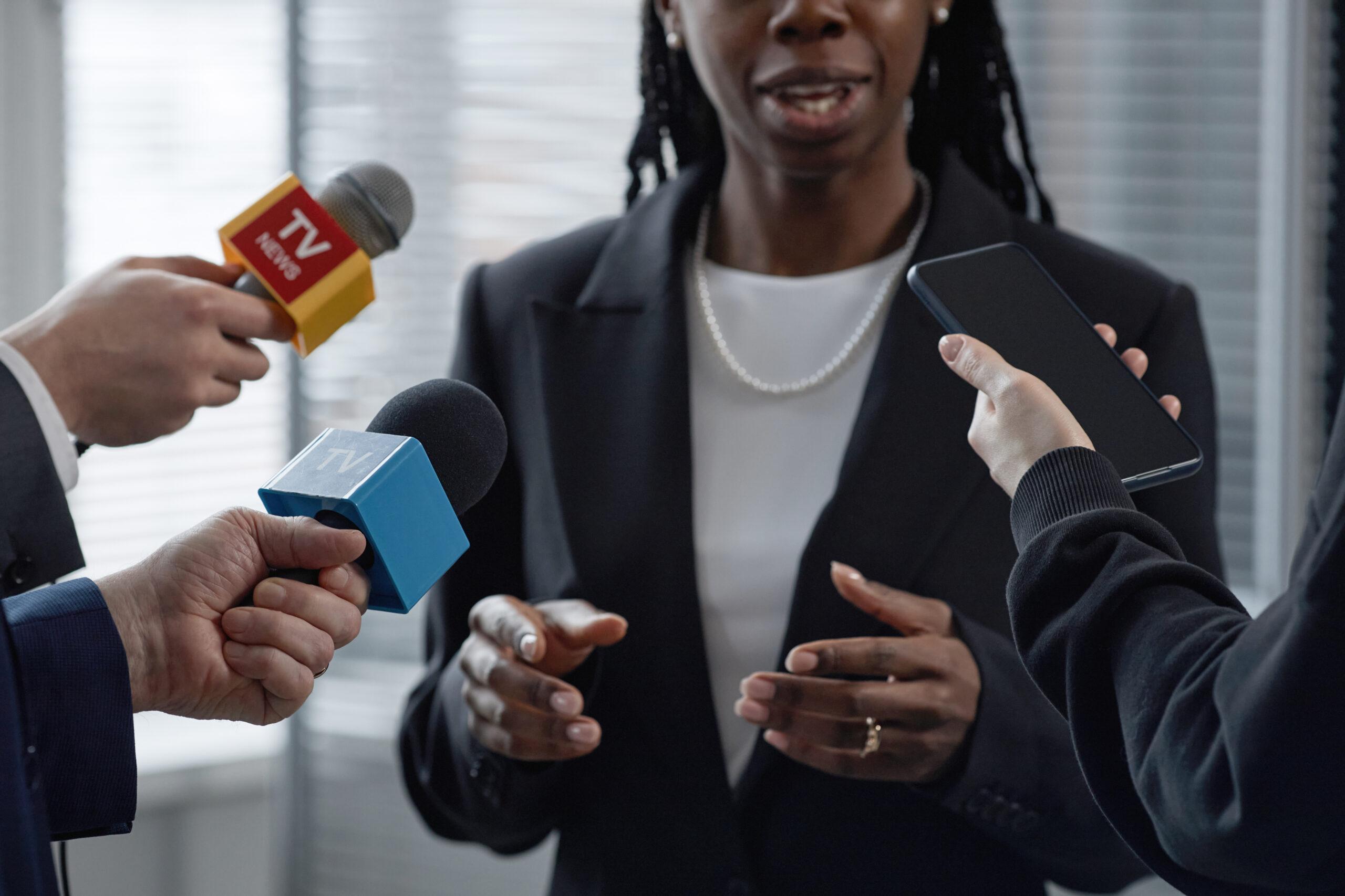 Black Female Official Giving Interview to Reporters Indoors