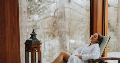 Pretty young woman relaxing by the indoor swimming pool at winter