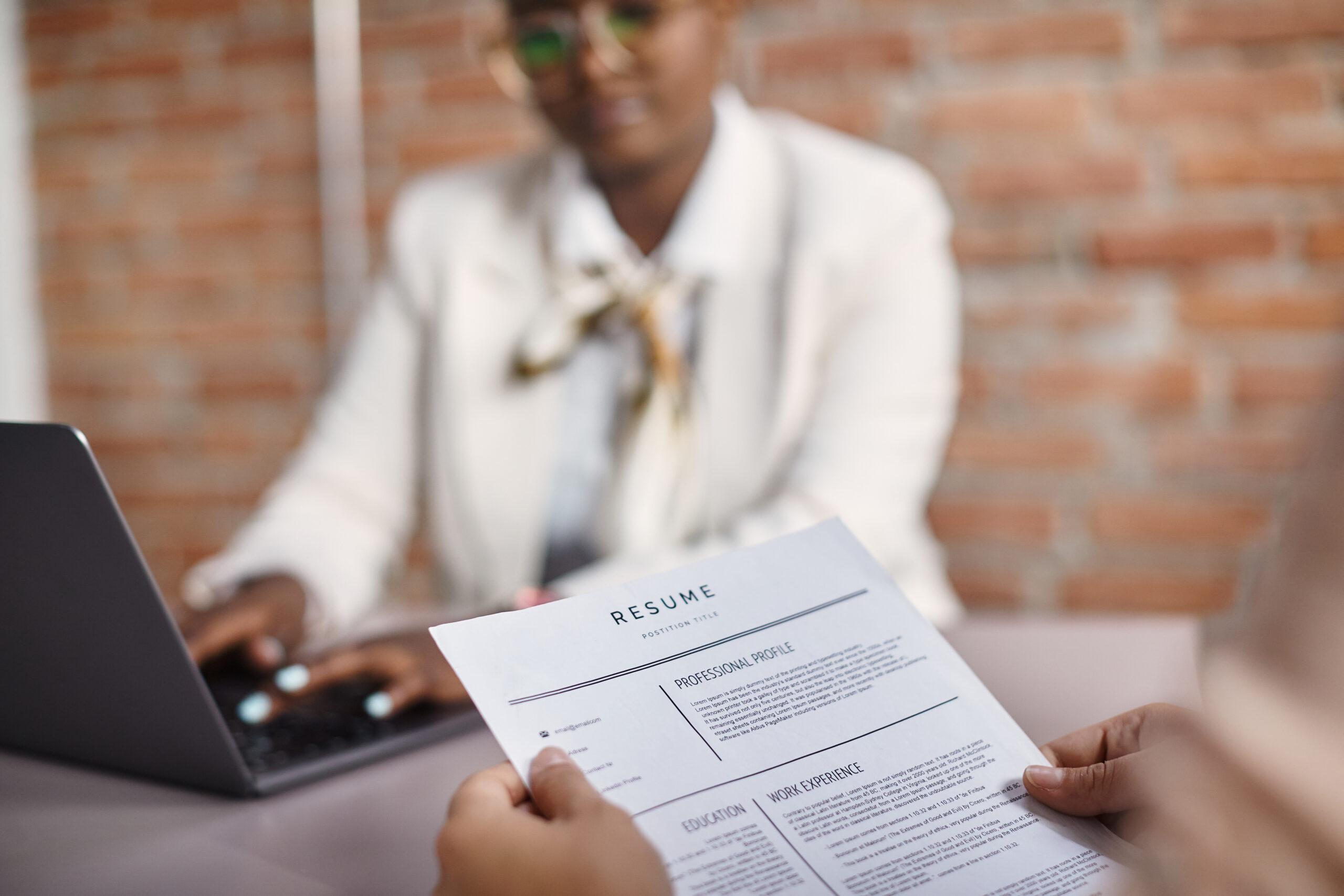 Close-up of job applicant holds her resume during the interview in corporate office.