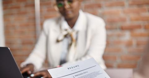Close-up of job applicant holds her resume during the interview in corporate office.