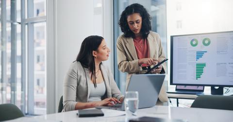 Business meeting, data analytics or women with graph presentation in office for tablet, idea or laptop collaboration. Chart, analysis or accounting team brainstorming economy, inflation or solution