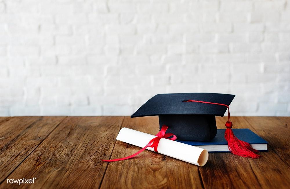 Graduation cap and diploma on a desk