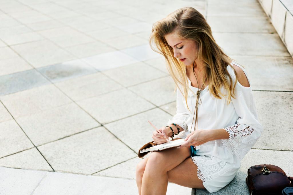 Boho stylish chic woman writing outdoors free image