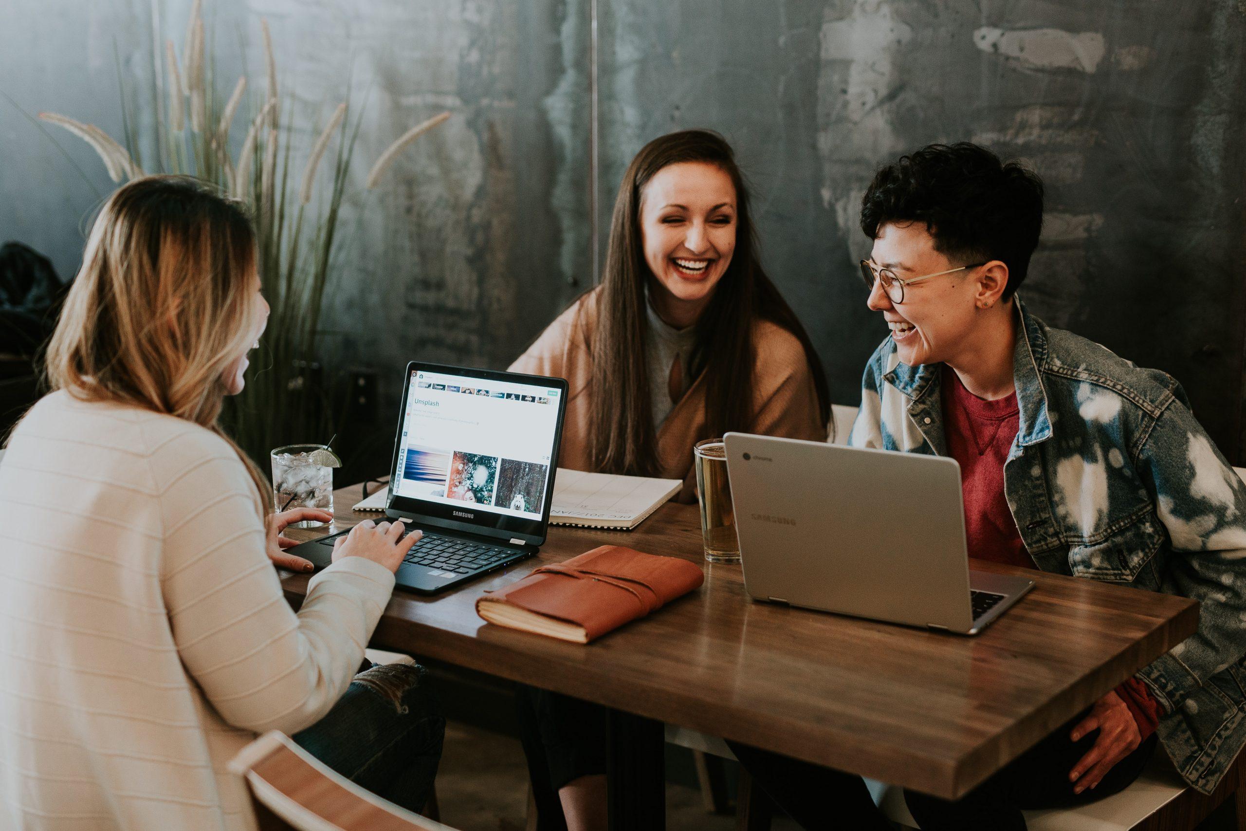 three women laughing at the table 